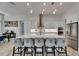 Kitchen island with seating, white cabinetry, stainless steel appliances, and modern pendant lights at 13539 Carryback Dr, Dade City, FL 33525