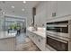Well-lit kitchen showcasing stainless steel double ovens, white cabinets and countertops, and breakfast nook at 13539 Carryback Dr, Dade City, FL 33525