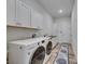 Spacious laundry room with white cabinets and sink at 13539 Carryback Dr, Dade City, FL 33525