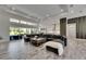 Open-concept living space with modern finishes, a large sectional sofa, and access to the outdoor pool area at 13539 Carryback Dr, Dade City, FL 33525