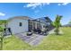 Back patio featuring a modern fire pit and outdoor seating, with a view of the pool and beautifully landscaped backyard at 13539 Carryback Dr, Dade City, FL 33525