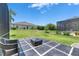Outdoor patio with a fire pit, surrounded by lush green grass and neighboring properties, providing a backyard retreat at 13539 Carryback Dr, Dade City, FL 33525