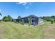 Spacious backyard featuring a screened-in pool, lush landscaping, and expansive green lawn, perfect for outdoor entertaining at 13539 Carryback Dr, Dade City, FL 33525