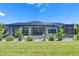 Backyard featuring a screened-in pool with a patio area, surrounded by lush greenery and well-maintained landscaping at 13539 Carryback Dr, Dade City, FL 33525