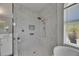 Walk-in shower with elegant tile, rainfall showerhead, and a built-in niche for storage at 13539 Carryback Dr, Dade City, FL 33525