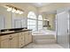 A bathroom with dual vanities, large mirrors, a shower and a garden tub at 15314 Sherwood Forest Dr, Tampa, FL 33647