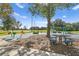 Community playground with a picnic table, climbing structures, and play equipment surrounded by trees at 15314 Sherwood Forest Dr, Tampa, FL 33647