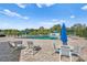 Community pool with lounge chairs and umbrellas, with beautiful trees in the background on a sunny day at 15314 Sherwood Forest Dr, Tampa, FL 33647