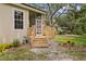 A screened porch features a wooden deck and stairs with a verdant lawn and landscape surrounding it at 15314 Sherwood Forest Dr, Tampa, FL 33647
