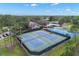 Aerial view of tennis and basketball courts near pool, clubhouse, parking, and trees at 15417 Martinmeadow Dr, Lithia, FL 33547