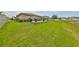 Lush green yard with a charming patio area that offers scenic views of the tranquil lake at 15426 Wicked Strong St, Sun City Center, FL 33573