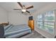 This bedroom features a ceiling fan, a window, and light gray plank flooring at 15426 Wicked Strong St, Sun City Center, FL 33573