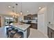 Open dining area flowing into a modern kitchen with an island, ideal for seamless entertaining and Gathering meals at 15426 Wicked Strong St, Sun City Center, FL 33573