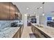 The kitchen features granite countertops, black appliances, ample cabinet space, and an island with a sink at 15426 Wicked Strong St, Sun City Center, FL 33573