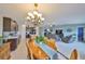 Open-concept living space featuring a spacious kitchen, dining area with elegant chandelier, and comfortable living room at 15426 Wicked Strong St, Sun City Center, FL 33573