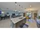 Open-concept living area featuring a central island with seating, dining area, and comfortable living room at 15426 Wicked Strong St, Sun City Center, FL 33573