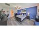 Bright main bedroom with a blue accent wall, ceiling fan, and view of the water at 15426 Wicked Strong St, Sun City Center, FL 33573