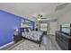 Bright main bedroom with a blue accent wall, ceiling fan, and view of the water at 15426 Wicked Strong St, Sun City Center, FL 33573