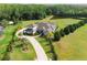 Aerial view showcasing the estate's lush greenery, mature trees, tranquil pond, and long paver driveway at 17305 Ballmont Park Dr, Odessa, FL 33556