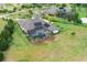 Large screened pool is surrounded by lush landscaping, mature trees, and a vast green lawn at 17305 Ballmont Park Dr, Odessa, FL 33556