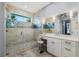 Bright bathroom featuring white cabinets, marble countertops, glass shower with accent tiles and a window at 17305 Ballmont Park Dr, Odessa, FL 33556