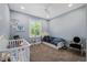 This bedroom features a crib, a small bed, a large window, and a chair at 17305 Ballmont Park Dr, Odessa, FL 33556