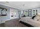 Bright and airy bedroom features large windows with white shutters, a ceiling fan, and a gray accent wall at 17305 Ballmont Park Dr, Odessa, FL 33556