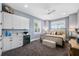 Bedroom with white cabinets, mini-refrigerator, neutral-colored walls, carpet, and ceiling fan at 17305 Ballmont Park Dr, Odessa, FL 33556