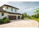 Two-story home featuring a three-car garage and a circular paved driveway at 17305 Ballmont Park Dr, Odessa, FL 33556