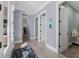 Hallway with light wood floors, blue walls, white trim, and doors leading to various rooms at 17305 Ballmont Park Dr, Odessa, FL 33556