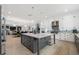 Open kitchen features a large gray island with marble countertops, stainless steel appliances, and an adjacent dining area at 17305 Ballmont Park Dr, Odessa, FL 33556