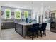 Modern kitchen with gray and white cabinetry, a marble island, stainless steel appliances, and stylish light fixtures at 17305 Ballmont Park Dr, Odessa, FL 33556