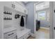 Convenient mudroom with white cabinets, a bench, storage hooks, and access to the laundry area at 17305 Ballmont Park Dr, Odessa, FL 33556