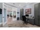 Spacious office featuring gray built-in storage, a modern desk, and an open doorway to a living room at 17305 Ballmont Park Dr, Odessa, FL 33556