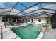 Beautiful screened-in pool area with a water feature, outdoor bar and seating at 17305 Ballmont Park Dr, Odessa, FL 33556