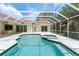 Backyard pool and patio area with tiled roof and screened-in enclosure at 17812 Arbor Greene Dr, Tampa, FL 33647