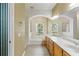 Bright bathroom with arched window, garden tub, and double vanity sink at 17812 Arbor Greene Dr, Tampa, FL 33647