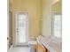 Bathroom with shower, door to outside, toilet, and vanity at 17812 Arbor Greene Dr, Tampa, FL 33647