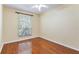 Bedroom featuring polished wood floors, neutral walls, and a window that brightens the room at 17812 Arbor Greene Dr, Tampa, FL 33647