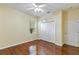 Cozy bedroom featuring wood floors, a double door closet, and a white ceiling fan at 17812 Arbor Greene Dr, Tampa, FL 33647