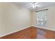 Bright bedroom with gleaming hardwood floors, a ceiling fan, and a large window at 17812 Arbor Greene Dr, Tampa, FL 33647