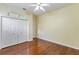 This bedroom features hardwood floors, a ceiling fan, a closet, and bright lighting at 17812 Arbor Greene Dr, Tampa, FL 33647