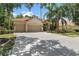 Spacious property featuring a three-car garage, driveway, lush landscaping, and a terracotta tiled roof at 17812 Arbor Greene Dr, Tampa, FL 33647