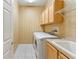 Bright laundry room features a washer, dryer, overhead cabinets, and a sink at 17812 Arbor Greene Dr, Tampa, FL 33647