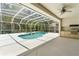 Screened in lanai with a well-maintained pool, hot tub, ceiling fan, and outdoor kitchen at 17812 Arbor Greene Dr, Tampa, FL 33647