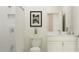 Clean white bathroom featuring a shower-tub combo, a vanity with storage and a modern artwork print at 18465 Serene Lake Loop, Lutz, FL 33548
