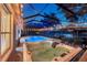Screened pool and jacuzzi area with outdoor dining, lighting, and view of pond at 19055 Lone Creek Ct, Land O Lakes, FL 34638