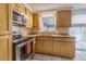 Well-maintained kitchen featuring light wood cabinets, granite countertops, and stainless steel appliances at 2039 Lyra Dr, Holiday, FL 34690