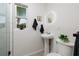 Bathroom with a modern pedestal sink, round mirror, and a view from the window to the outside at 263 87Th N Ave, St Petersburg, FL 33702