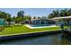 Exterior view of waterfront property with pool, boat dock and lush green landscaping from the water at 263 87Th N Ave, St Petersburg, FL 33702